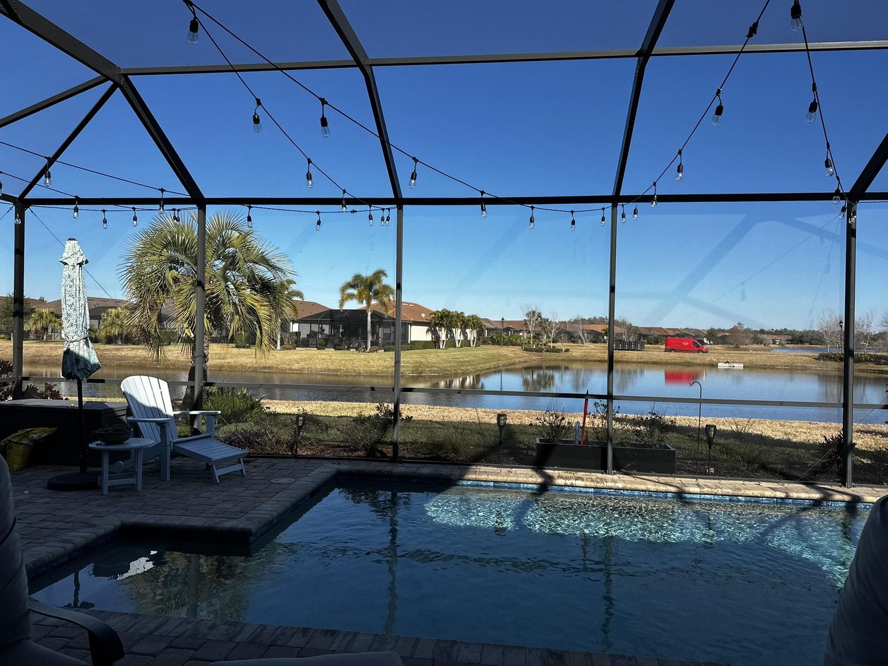 Tampa Bay pool cage with lakefront view — restored aluminum screen enclosure